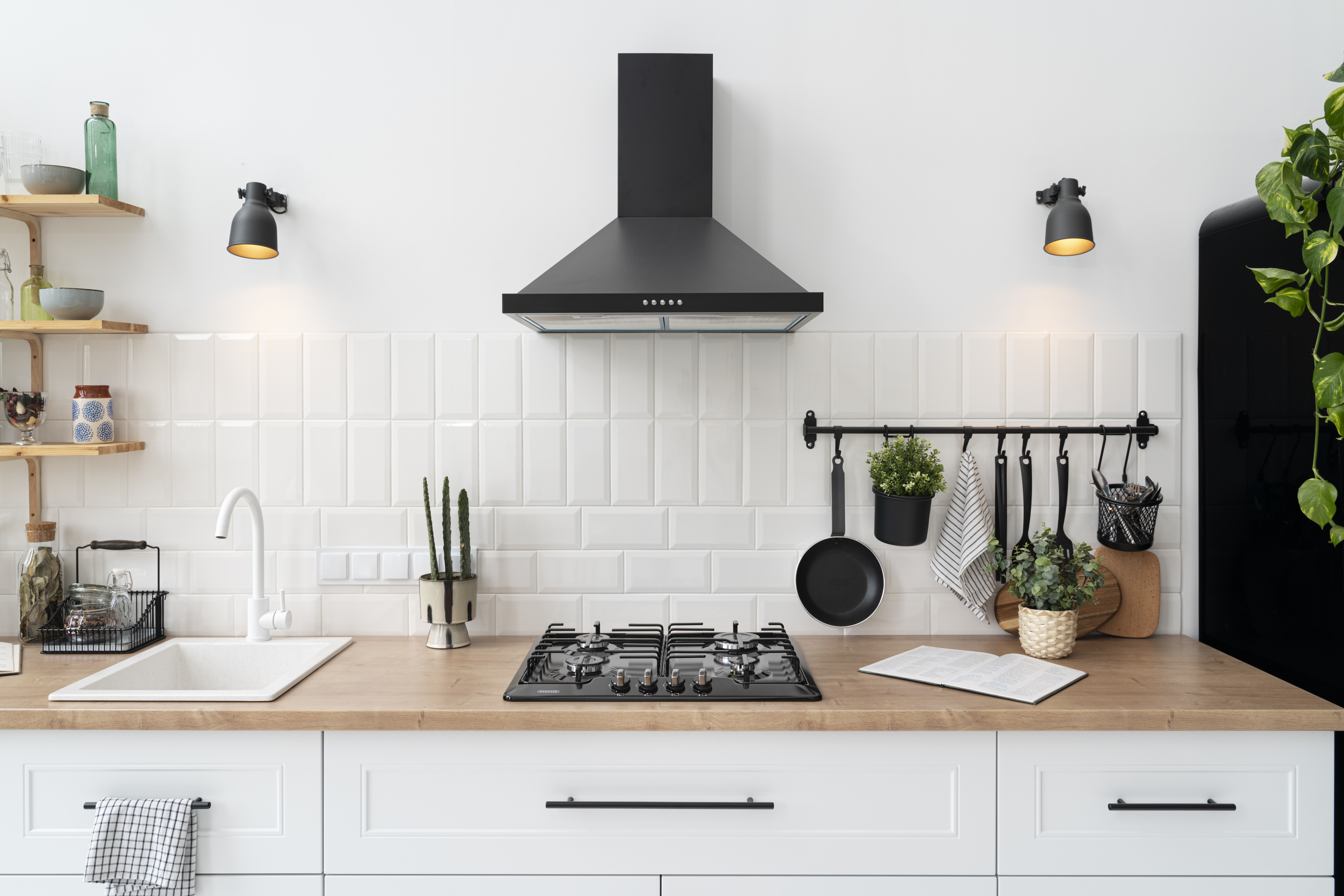 Tidy white kitchen with a gas hob and cooker hood