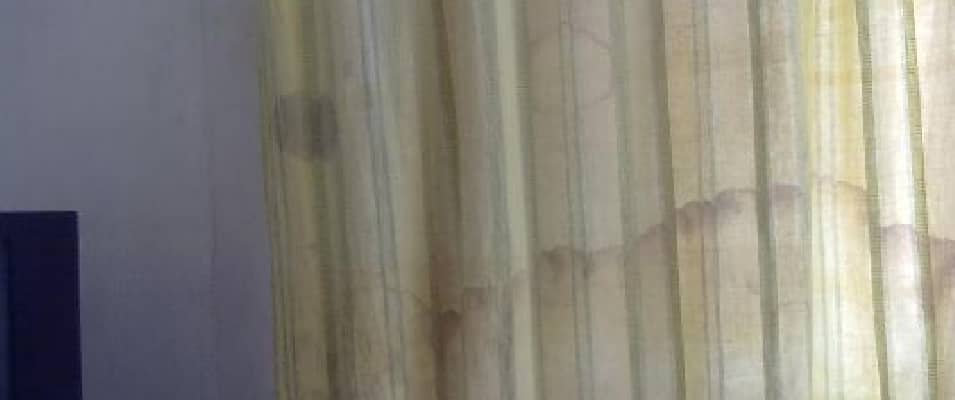 Curtain with yellow stains running down the fabric