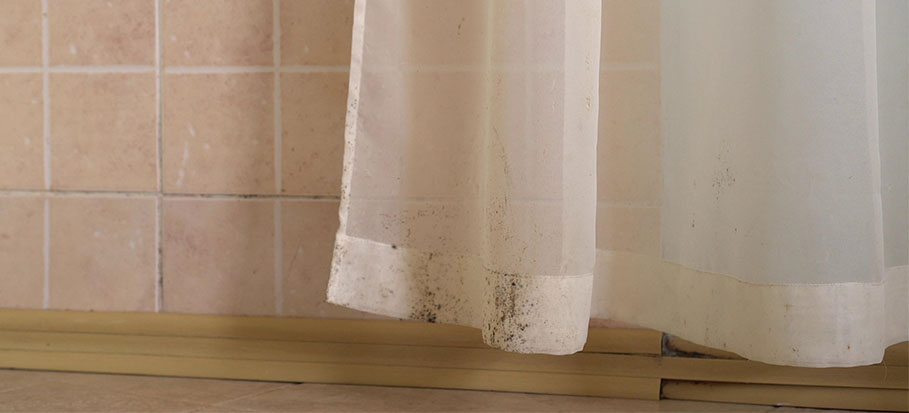 Sheer curtain with mould spots along the hem