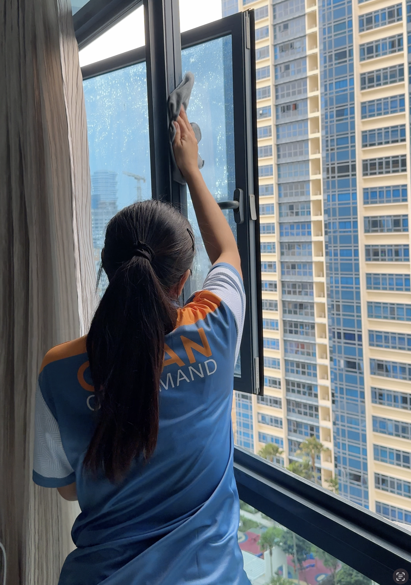 Clean On Demand cleaner wiping a window in a high-rise flat