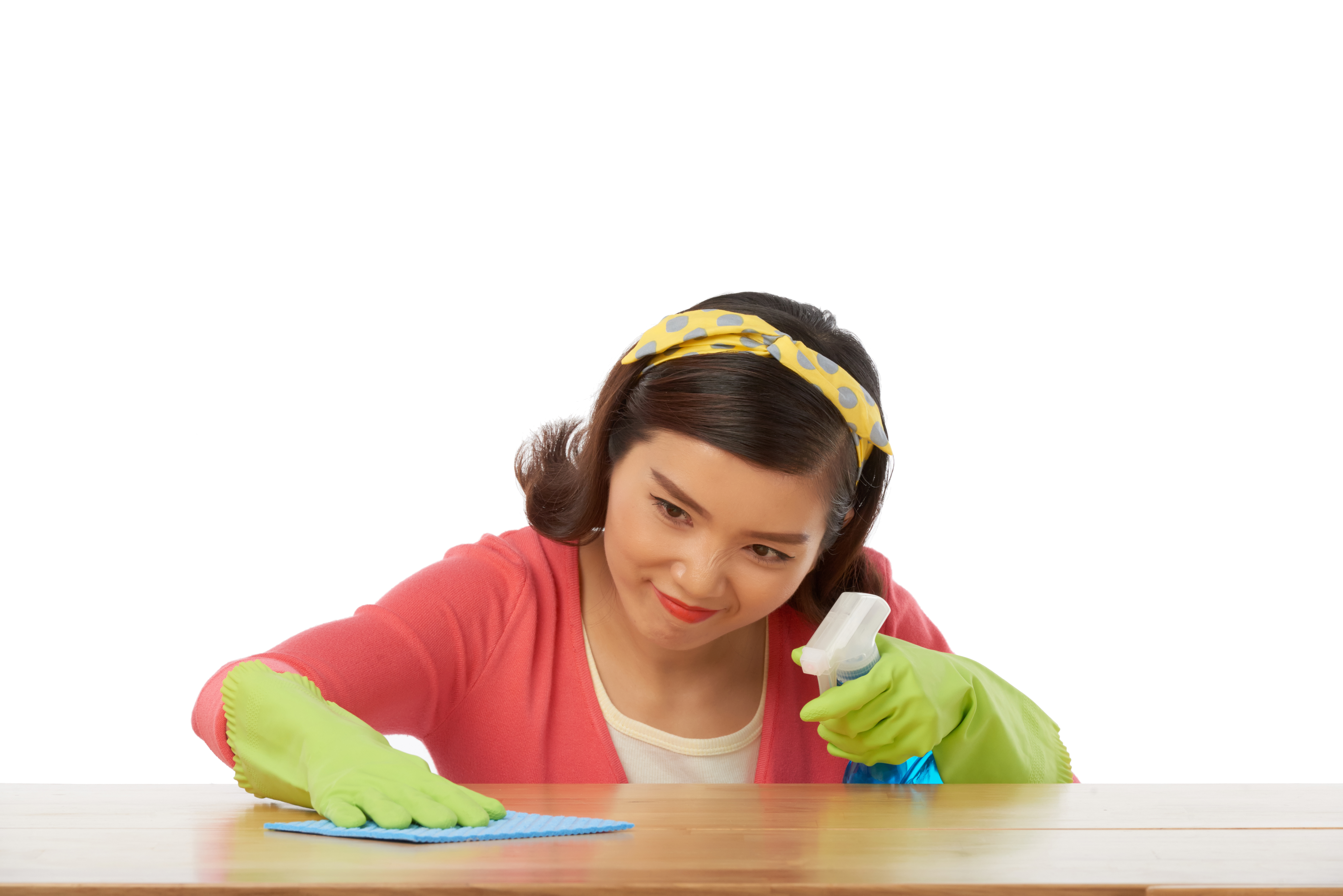 Woman wiping a table with a cloth and spray