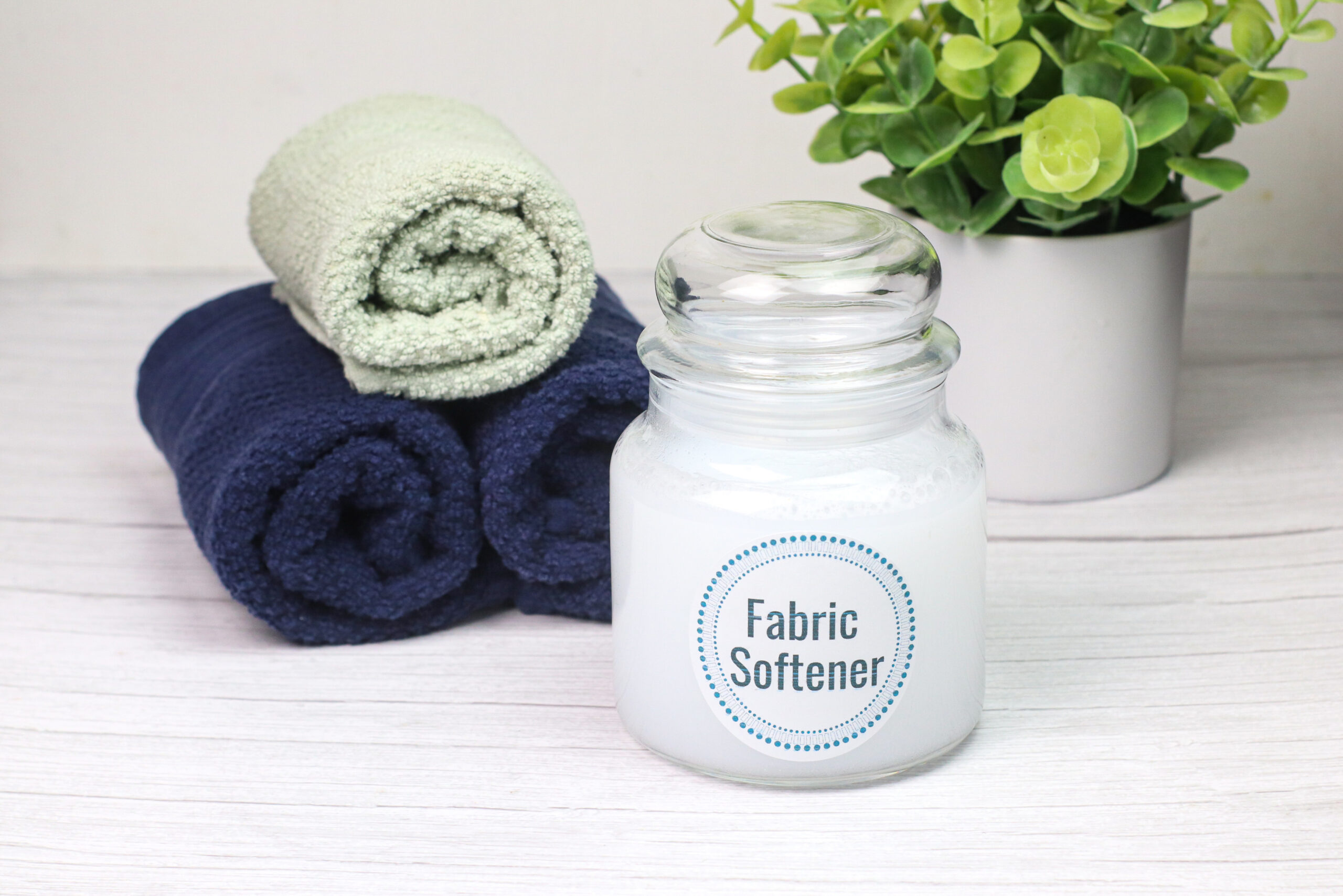 Jar of fabric softener next to folded towels