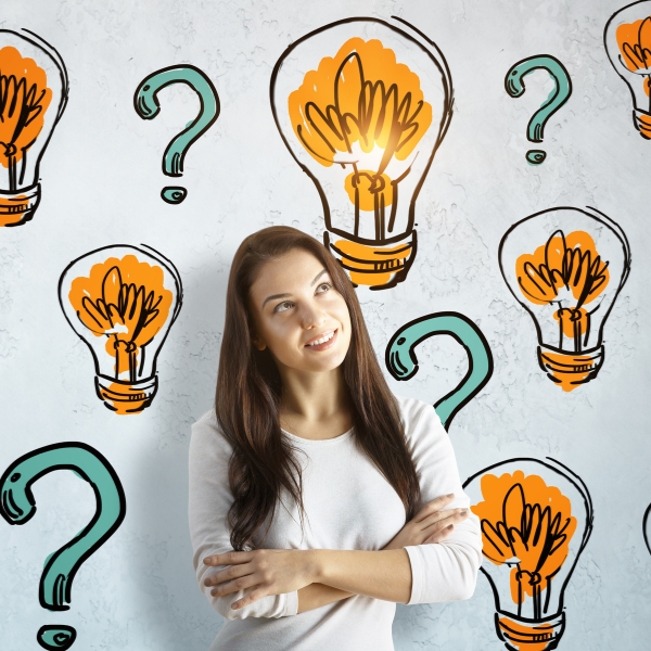 Woman surrounded by drawings of light bulbs and question marks