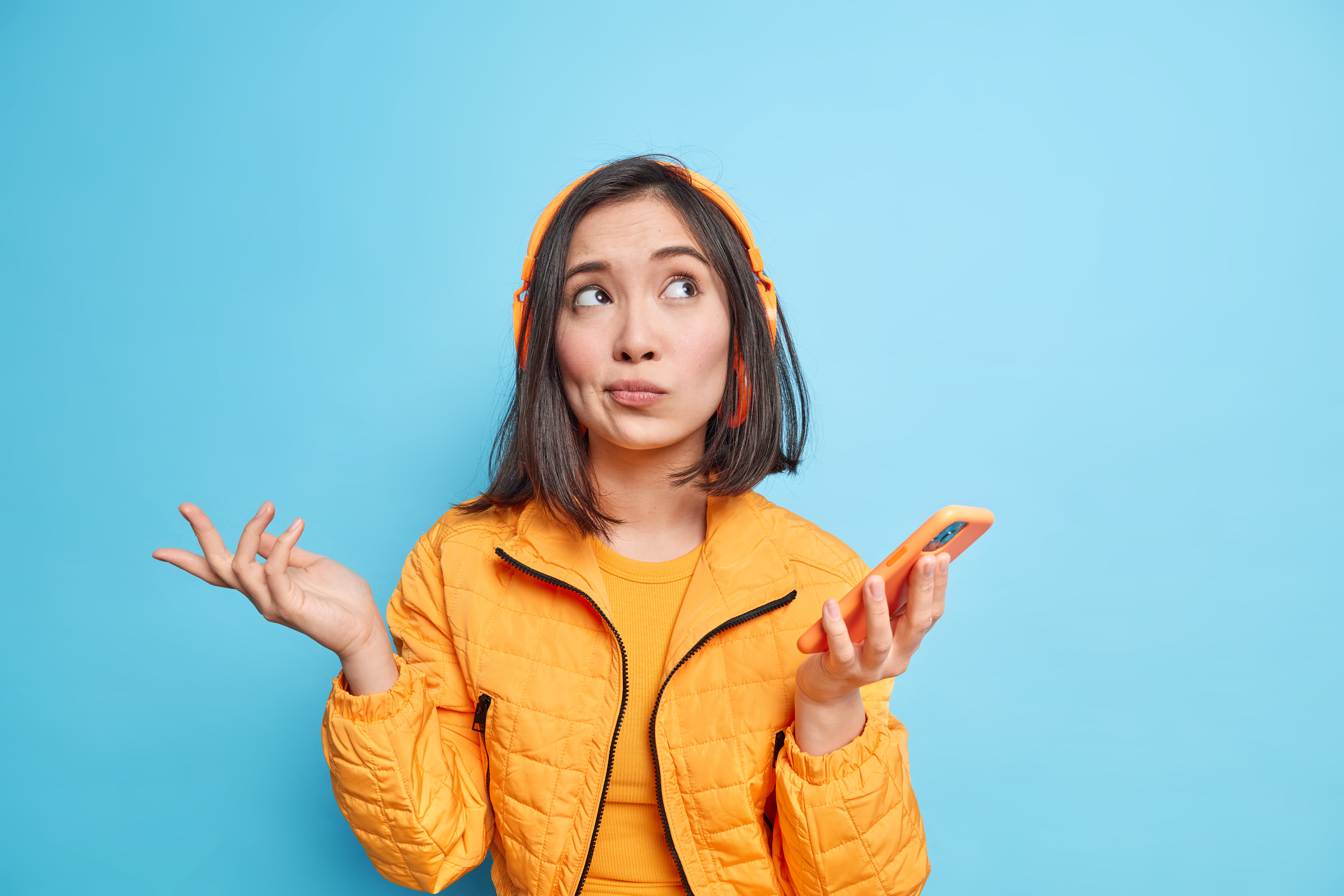 Woman holding a phone, unsure what to do